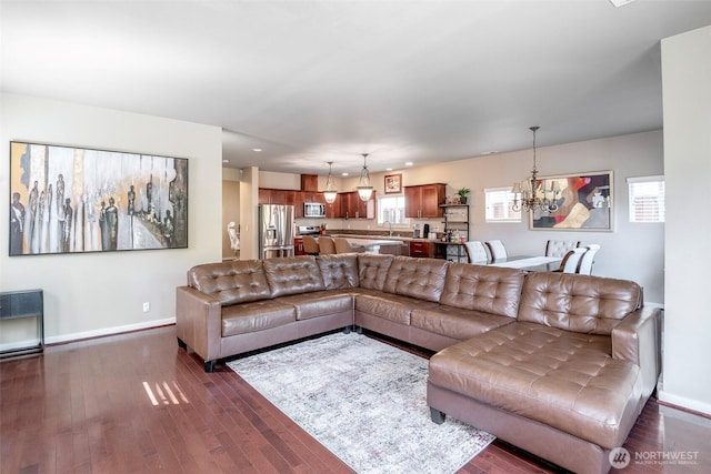 living room with an inviting chandelier, recessed lighting, baseboards, and dark wood-style floors