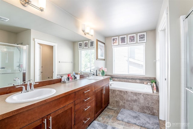 bathroom featuring double vanity, a sink, and a stall shower
