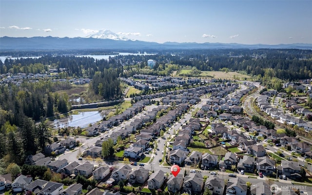 bird's eye view with a wooded view, a water and mountain view, and a residential view