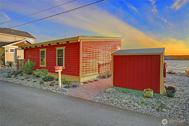 view of home's exterior with an outdoor structure and a storage shed