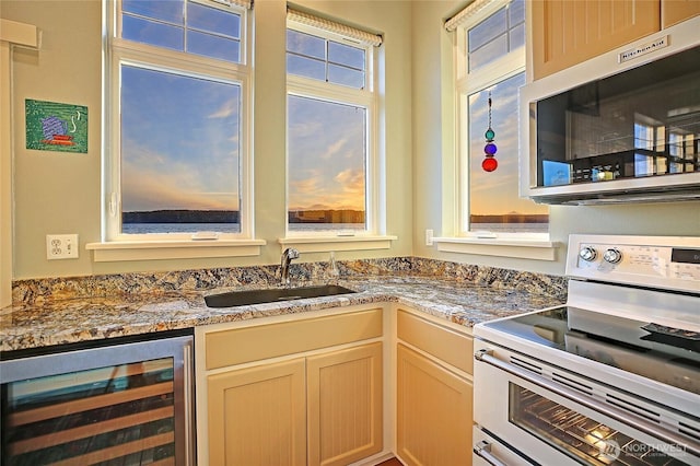 bar featuring wine cooler, a sink, stainless steel microwave, and white range with electric stovetop