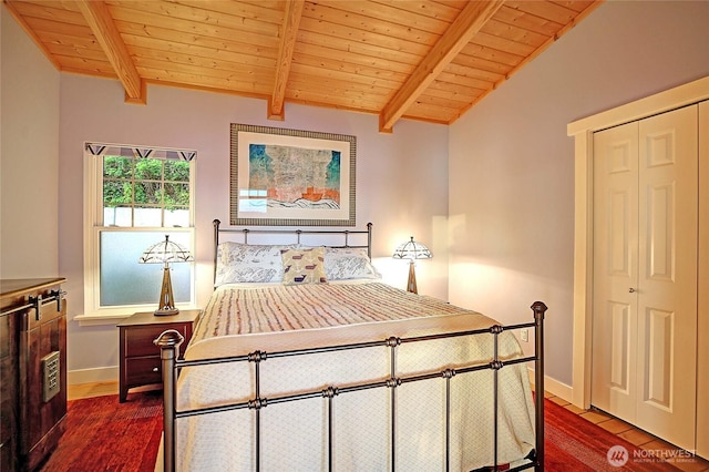 bedroom featuring wood ceiling, dark wood finished floors, baseboards, and a closet