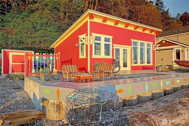 back of property with an outbuilding and a deck