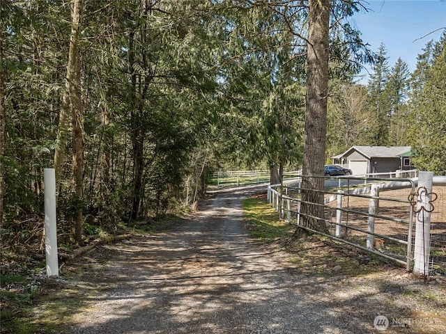 27709 293rd Ave SE, Ravensdale, WA 98051 - view of dirt / gravel driveway with a gate and a wooded view