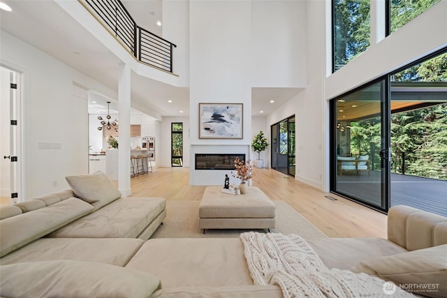 17720 SE 63rd Pl, Bellevue, WA 98006 - living area with light wood-type flooring, plenty of natural light, a glass covered fireplace, a high ceiling, and recessed lighting