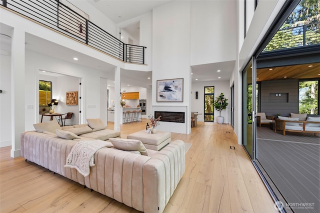 17720 SE 63rd Pl, Bellevue, WA 98006 - living room with light wood-type flooring, plenty of natural light, a high ceiling, and a glass covered fireplace