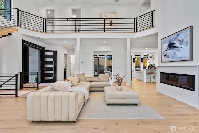 17720 SE 63rd Pl, Bellevue, WA 98006 - living area with a towering ceiling, plenty of natural light, wood finished floors, a glass covered fireplace, and stairs