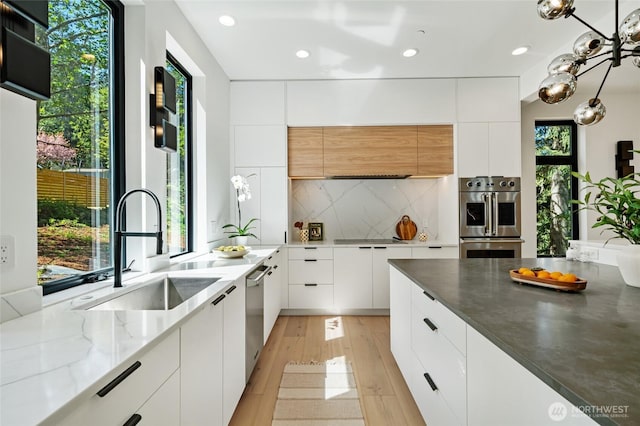17720 SE 63rd Pl, Bellevue, WA 98006 - kitchen featuring stainless steel appliances, modern cabinets, white cabinets, light wood finished floors, and recessed lighting
