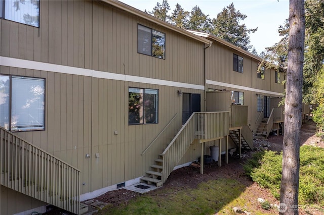 rear view of property featuring crawl space and stairs