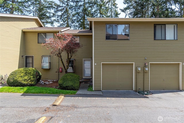 view of property featuring an attached garage and driveway