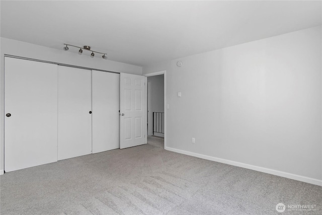 unfurnished bedroom with carpet flooring, a closet, and baseboards