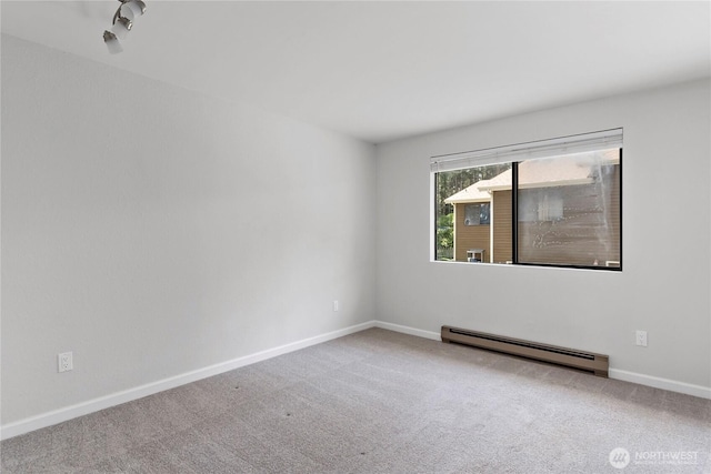 empty room with baseboards, carpet flooring, and a baseboard heating unit