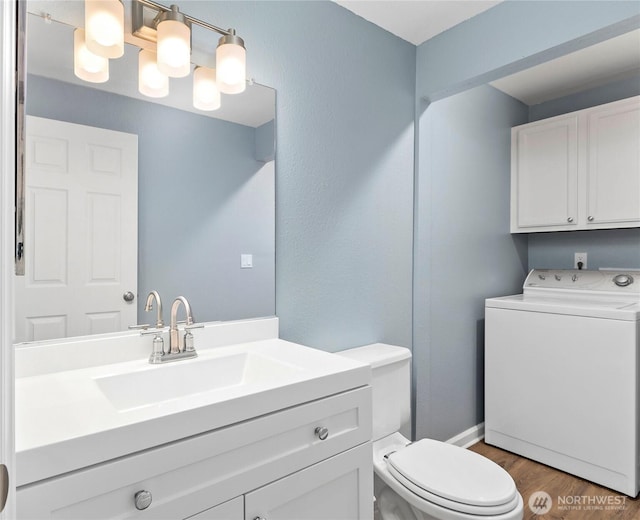 bathroom with toilet, wood finished floors, vanity, and baseboards