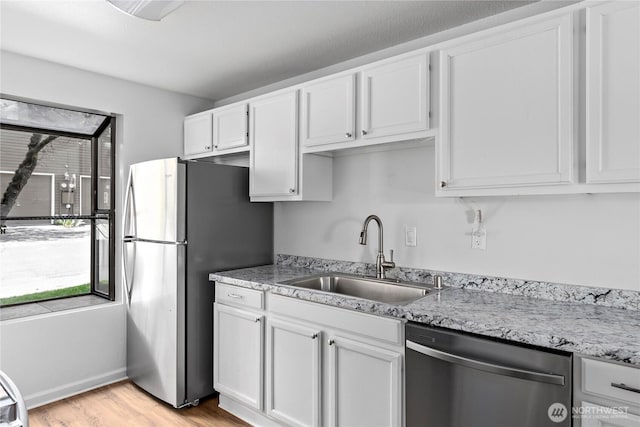 kitchen with white cabinets, a healthy amount of sunlight, stainless steel appliances, and a sink