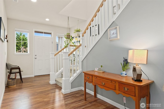foyer featuring recessed lighting, baseboards, wood finished floors, and stairway