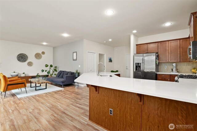 kitchen with recessed lighting, a sink, light countertops, and stainless steel appliances