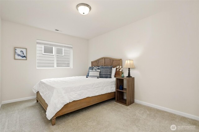 carpeted bedroom featuring baseboards and visible vents