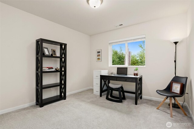 office featuring baseboards, visible vents, and light carpet