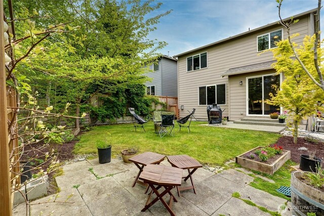 back of house with a lawn, a fenced backyard, a patio area, and a vegetable garden