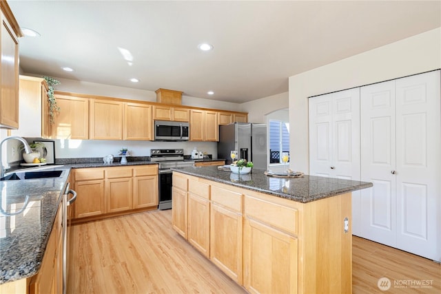 kitchen with recessed lighting, light wood finished floors, light brown cabinetry, stainless steel appliances, and a sink