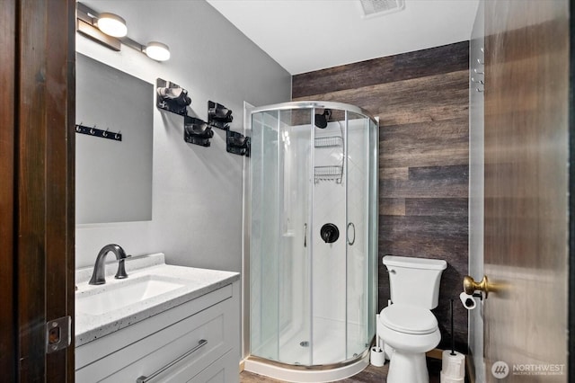 full bathroom with a shower stall, vanity, visible vents, and toilet