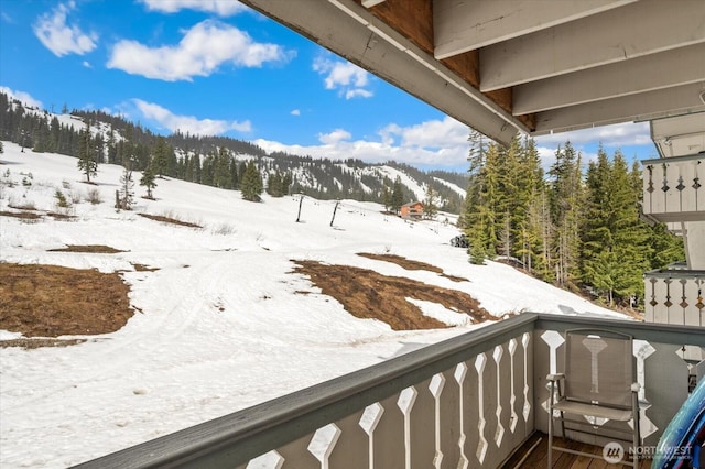 snow covered back of property with a mountain view