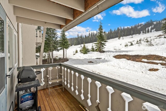 snow covered back of property featuring grilling area