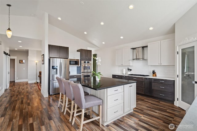 17908 NE 391st St, Amboy, WA 98601 - kitchen featuring dark wood finished floors, tasteful backsplash, wall chimney range hood, vaulted ceiling, and stainless steel appliances