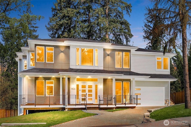 rear view of property featuring concrete driveway, covered porch, a garage, and fence