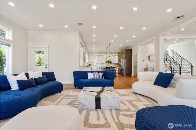 living area featuring light wood-style flooring, plenty of natural light, and recessed lighting
