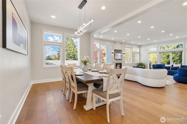 dining area with light wood-style flooring, a wealth of natural light, baseboards, and recessed lighting