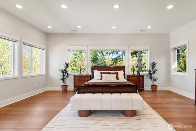 bedroom featuring wood finished floors, baseboards, and recessed lighting