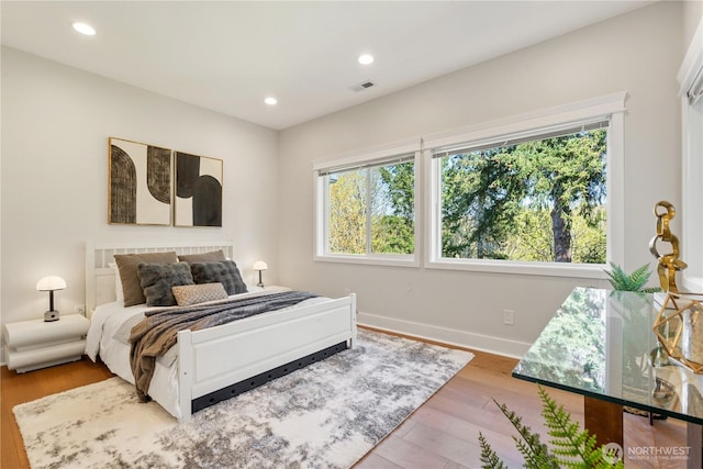bedroom featuring baseboards, recessed lighting, visible vents, and wood finished floors