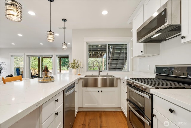 kitchen featuring a sink, stainless steel appliances, light wood-style flooring, and recessed lighting