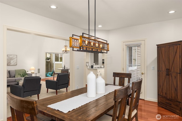 dining area featuring wood finished floors, recessed lighting, and a chandelier
