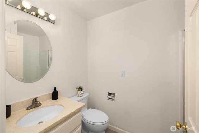 bathroom featuring toilet, vanity, and a shower