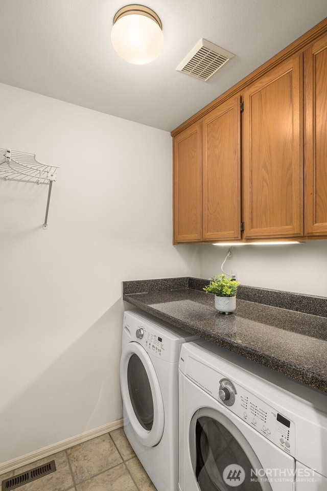 washroom with independent washer and dryer, cabinet space, and baseboards