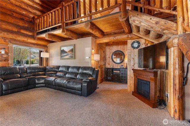 carpeted living room with rustic walls, a glass covered fireplace, wood ceiling, and beamed ceiling