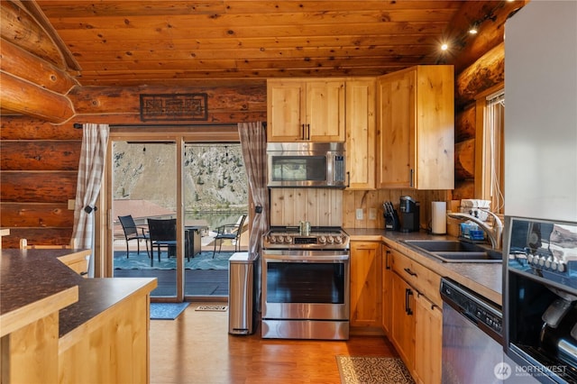 kitchen with a sink, rustic walls, light wood-type flooring, wooden ceiling, and appliances with stainless steel finishes
