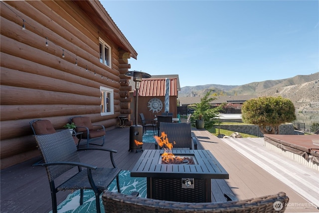 view of patio / terrace with a fire pit and a deck with mountain view