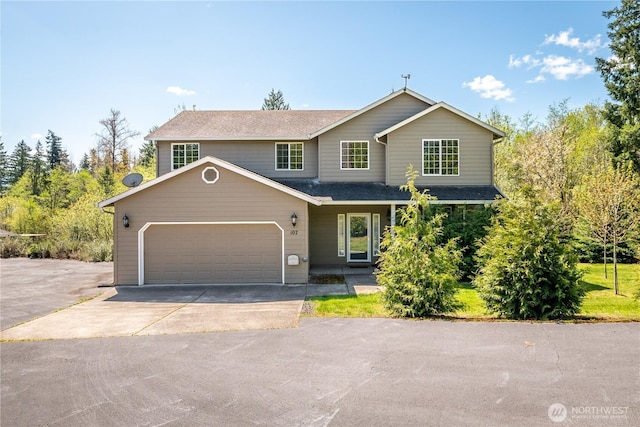 view of front of property with a shingled roof, driveway, and a garage