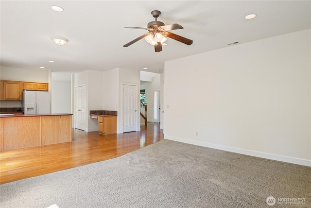 unfurnished living room with a ceiling fan, visible vents, recessed lighting, and light colored carpet