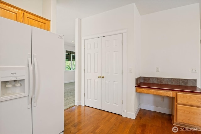 interior space with baseboards, wood finished floors, and built in desk
