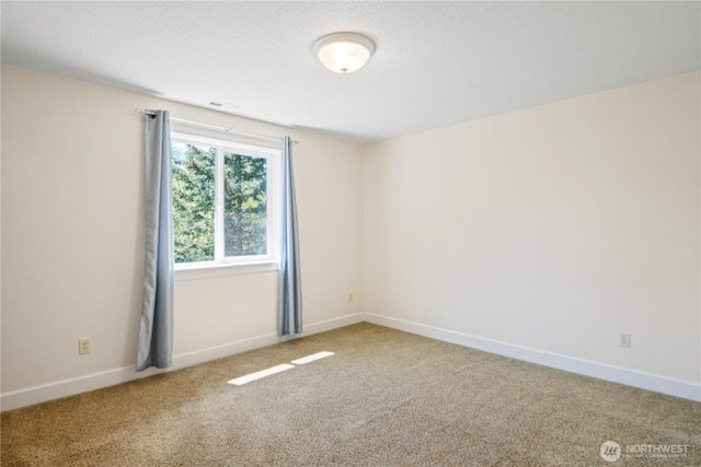 carpeted empty room with baseboards