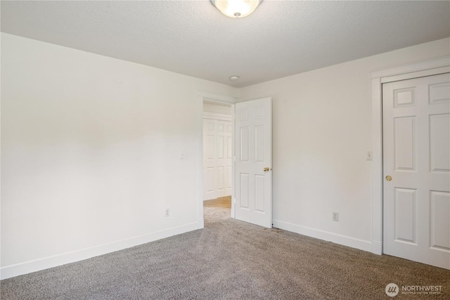 unfurnished bedroom with baseboards, a textured ceiling, and carpet