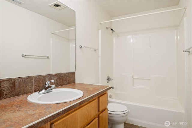 bathroom with shower / bathing tub combination, decorative backsplash, vanity, and toilet
