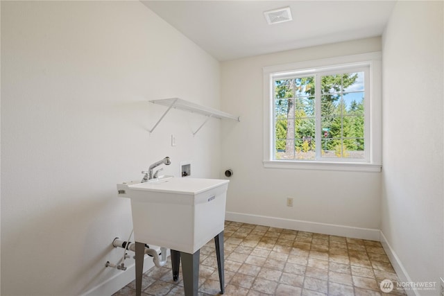 clothes washing area with laundry area, stone finish flooring, baseboards, visible vents, and washer hookup