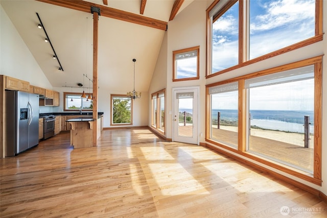 27 Scenic Dr, Brewster, WA 98812 - unfurnished living room with high vaulted ceiling, light wood-style flooring, track lighting, a chandelier, and baseboards