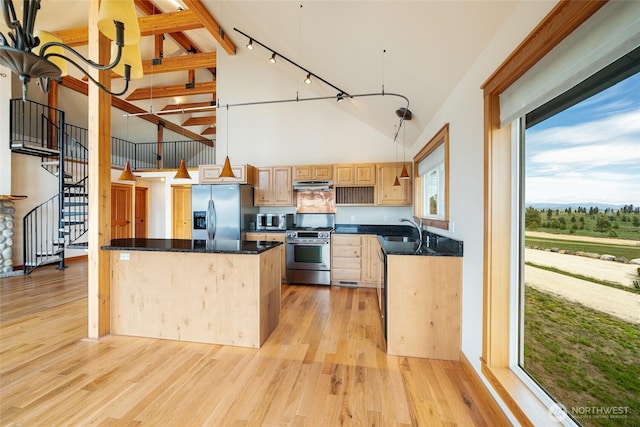 27 Scenic Dr, Brewster, WA 98812 - kitchen with stainless steel appliances, under cabinet range hood, high vaulted ceiling, light brown cabinets, and light wood finished floors