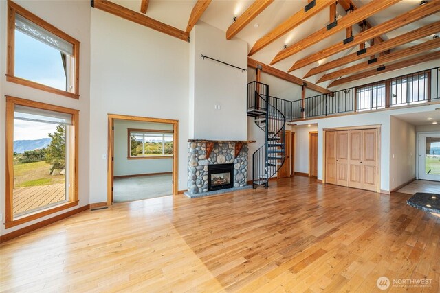 27 Scenic Dr, Brewster, WA 98812 - unfurnished living room featuring high vaulted ceiling, healthy amount of natural light, stairway, wood finished floors, and baseboards